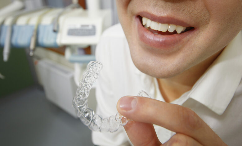 Smiling man holding silicone mouth guard